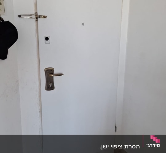 דלת לבנה עם ידית מתכת וחור מנעול